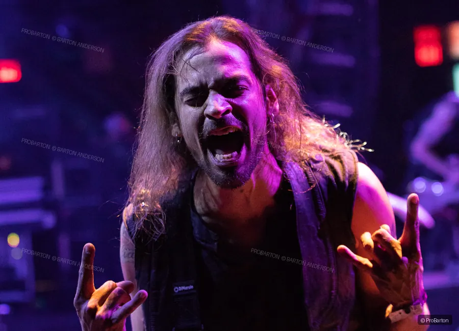 Live vocalist raising a hand during a concert performance